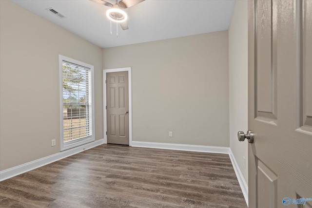 spare room with dark wood-type flooring and ceiling fan