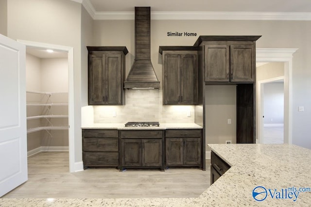 BELLEWOOD-B Mallard Dr, Madison, AL 35756 - kitchen featuring custom exhaust hood, stainless steel gas stovetop, dark brown cabinetry, light wood-type flooring, and crown molding