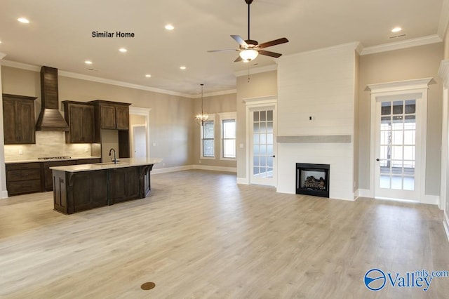 BELLEWOOD-B Mallard Dr, Madison, AL 35756 - kitchen featuring custom exhaust hood, an island with sink, light countertops, a large fireplace, and ceiling fan
