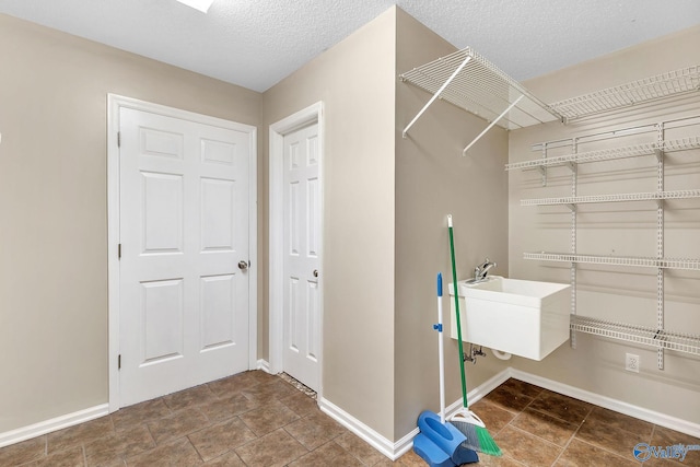 laundry area featuring sink and a textured ceiling