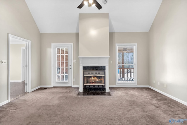 unfurnished living room featuring a premium fireplace, lofted ceiling, carpet floors, and ceiling fan