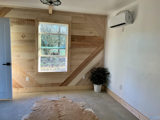 interior space featuring wood walls, a healthy amount of sunlight, concrete flooring, and a wall mounted AC