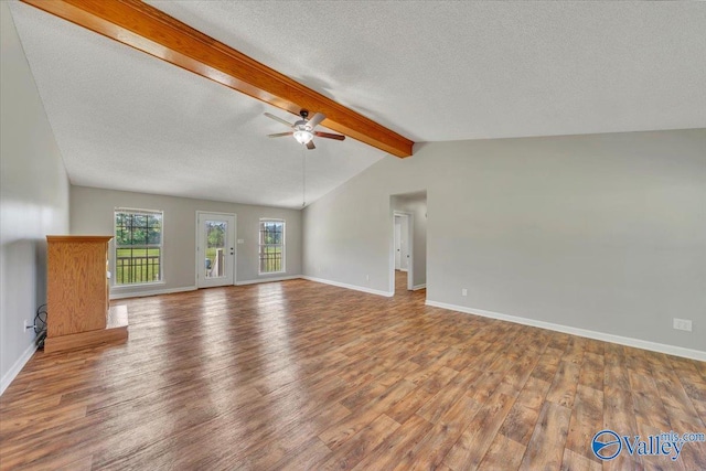 unfurnished living room featuring ceiling fan, a textured ceiling, wood finished floors, and lofted ceiling with beams