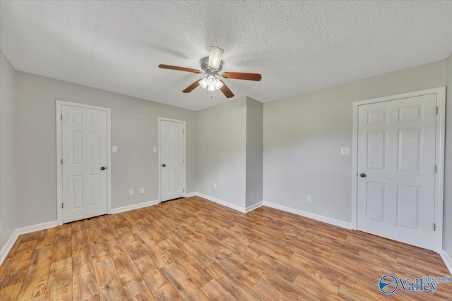 unfurnished room featuring light wood finished floors, baseboards, a textured ceiling, and ceiling fan