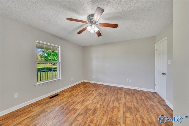 unfurnished room with visible vents, baseboards, a ceiling fan, and wood finished floors