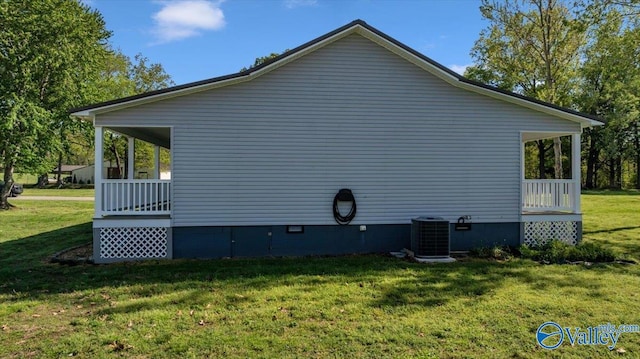 view of side of home with a yard, central AC unit, and crawl space