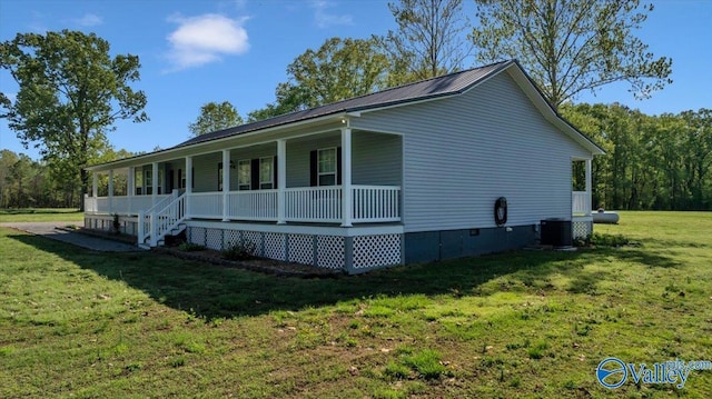 view of side of home featuring metal roof, a lawn, covered porch, crawl space, and central air condition unit
