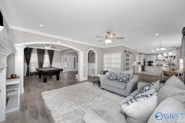 living room featuring ceiling fan with notable chandelier, crown molding, pool table, and light hardwood / wood-style flooring