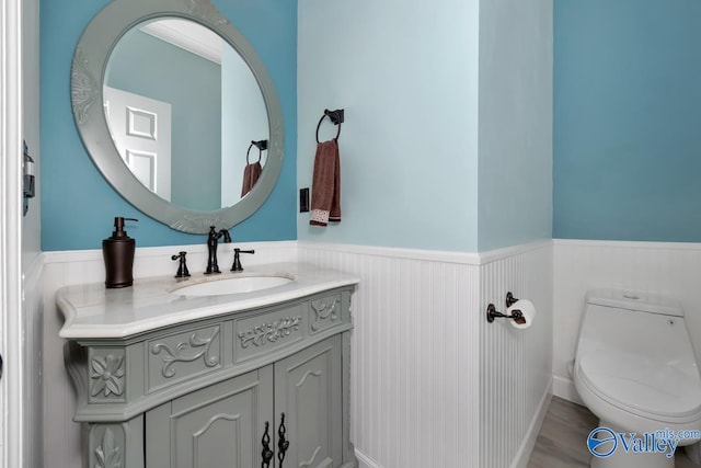 bathroom featuring wood-type flooring, vanity, and toilet