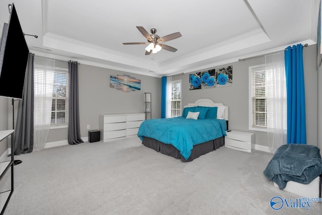 carpeted bedroom featuring a raised ceiling, ceiling fan, and ornamental molding