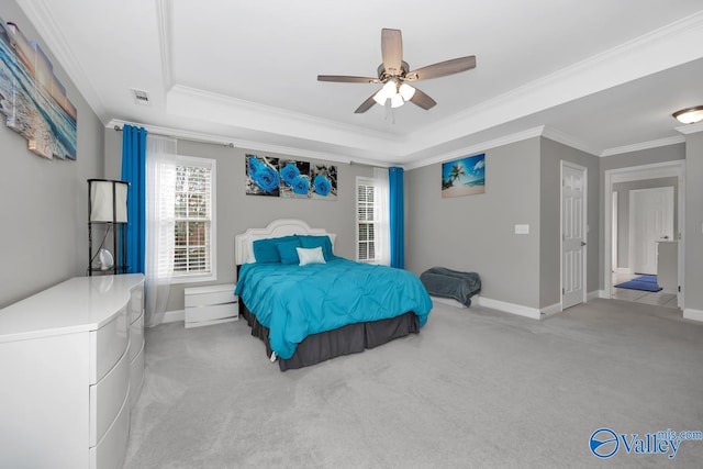 bedroom with a raised ceiling, ceiling fan, crown molding, and light carpet