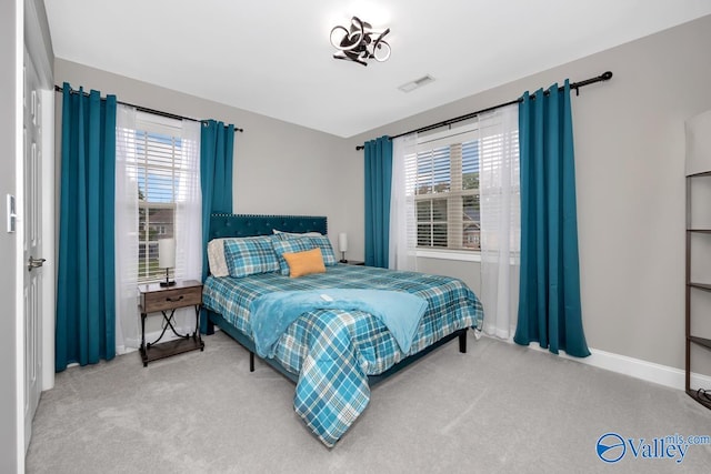 carpeted bedroom with multiple windows