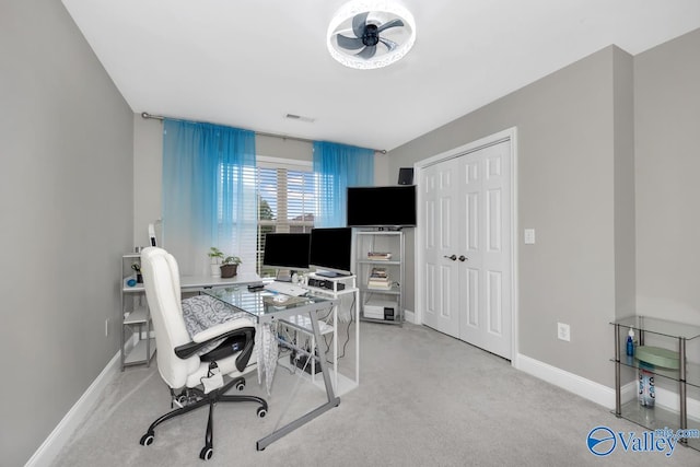 carpeted office space featuring ceiling fan