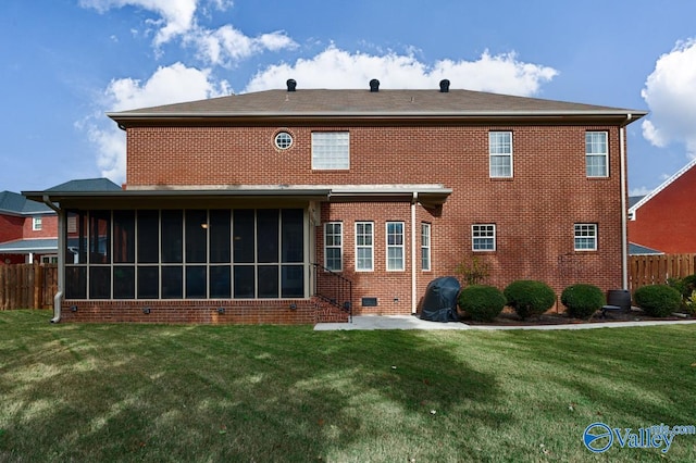 rear view of house featuring a sunroom and a yard