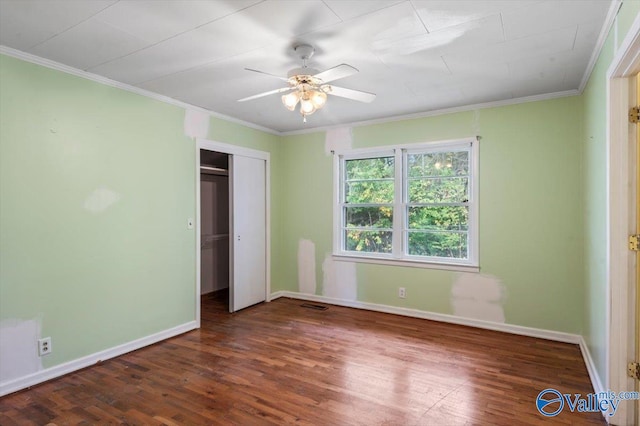 unfurnished bedroom featuring dark wood-type flooring, ceiling fan, a closet, and ornamental molding