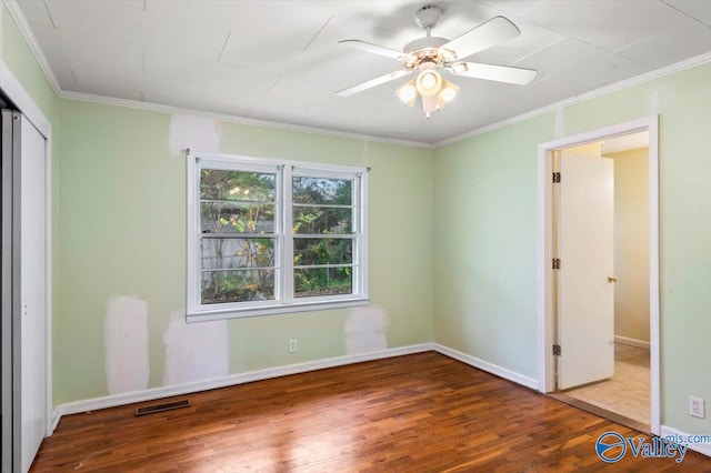 unfurnished bedroom with ornamental molding, hardwood / wood-style flooring, ceiling fan, and a closet