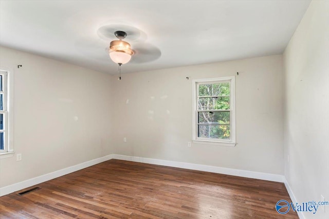 spare room with dark hardwood / wood-style floors and ceiling fan