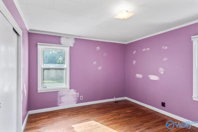 spare room featuring hardwood / wood-style flooring and ornamental molding