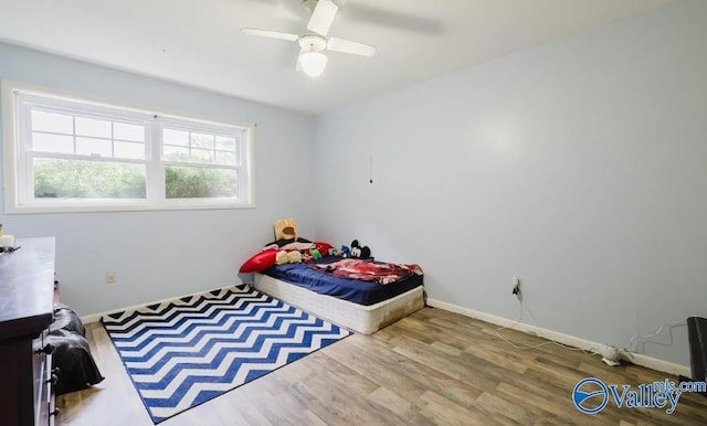 bedroom featuring a ceiling fan, baseboards, and wood finished floors