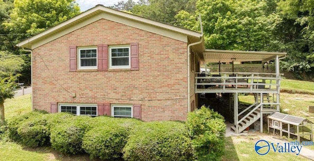 view of property exterior with stairs, brick siding, and a deck