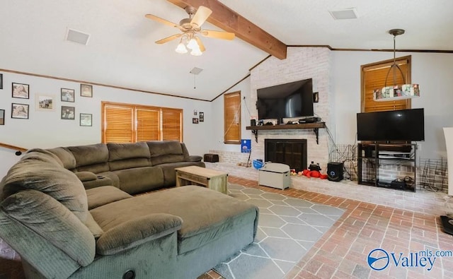 living area featuring brick floor, crown molding, lofted ceiling with beams, a ceiling fan, and a brick fireplace