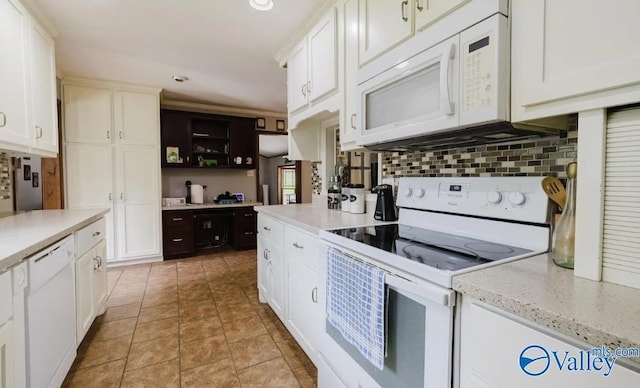 kitchen featuring tasteful backsplash, white appliances, light tile patterned floors, and white cabinets