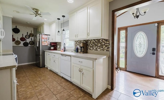 kitchen with freestanding refrigerator, white cabinetry, dishwasher, and decorative backsplash