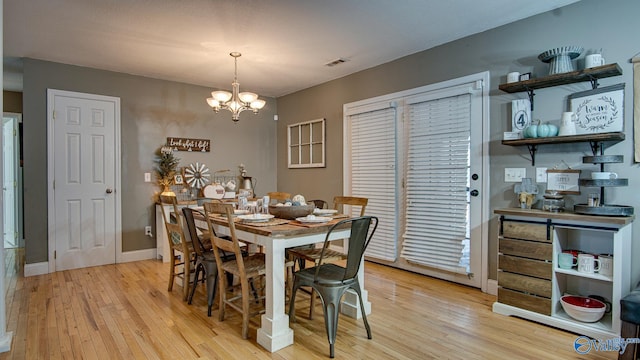 dining room with a notable chandelier and light hardwood / wood-style floors