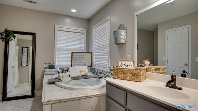 bathroom featuring tile patterned floors, vanity, and tiled tub