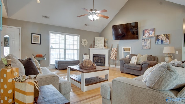 living room featuring light hardwood / wood-style floors, high vaulted ceiling, and ceiling fan