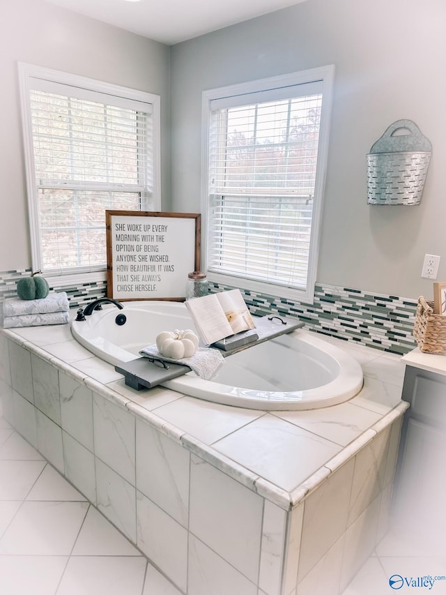 bathroom with tile patterned floors and tiled tub