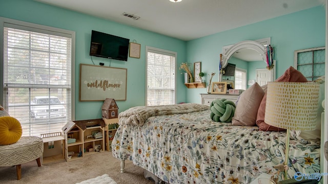 bedroom featuring multiple windows and light carpet