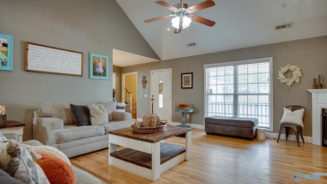 living room featuring ceiling fan, high vaulted ceiling, and light hardwood / wood-style floors