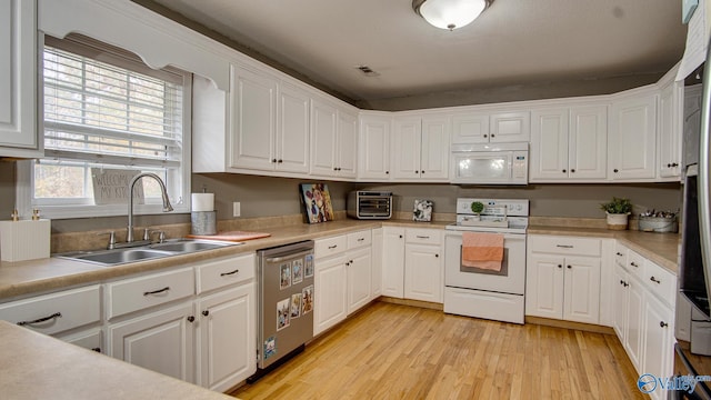 kitchen featuring white cabinetry, sink, light hardwood / wood-style floors, and white appliances