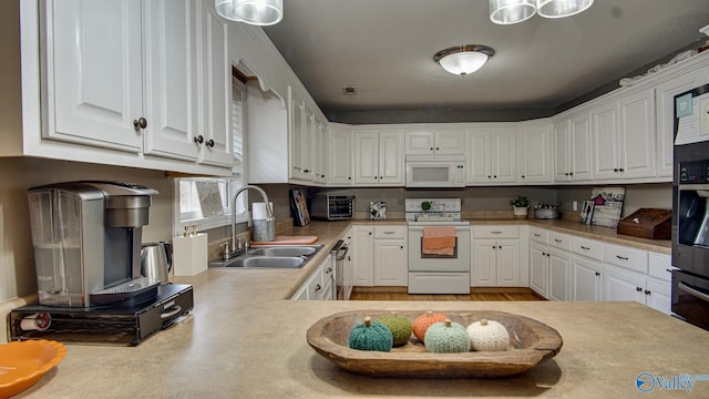 kitchen featuring white cabinets, white appliances, kitchen peninsula, and sink