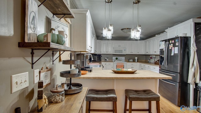 kitchen featuring pendant lighting, a breakfast bar, white appliances, white cabinets, and kitchen peninsula