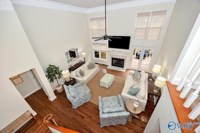 2616 Bransford Trl SE, Owens Cross Roads, AL 35763 - living area featuring a towering ceiling, crown molding, ceiling fan, a tile fireplace, and wood finished floors