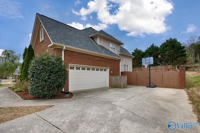 2616 Bransford Trl SE, Owens Cross Roads, AL 35763 - view of side of property featuring roof with shingles, brick siding, driveway, and fence