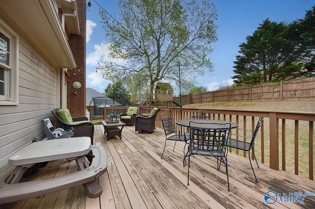 2616 Bransford Trl SE, Owens Cross Roads, AL 35763 - wooden deck with a trampoline, fence, and outdoor dining area