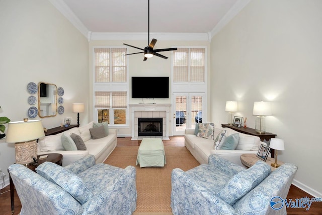 2616 Bransford Trl SE, Owens Cross Roads, AL 35763 - living room with crown molding, ceiling fan, wood finished floors, a tiled fireplace, and baseboards