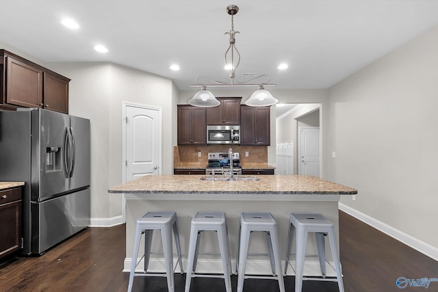158 Kenton Ln, Madison, AL 35756 - kitchen featuring decorative backsplash, a kitchen bar, dark brown cabinetry, and stainless steel appliances