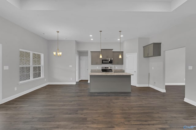 kitchen featuring a kitchen island with sink, appliances with stainless steel finishes, decorative light fixtures, and gray cabinetry