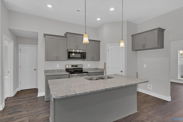 kitchen featuring appliances with stainless steel finishes, sink, dark hardwood / wood-style flooring, decorative light fixtures, and light stone counters