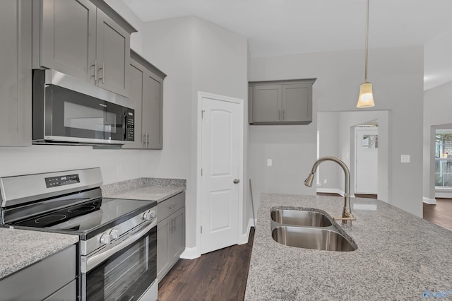 kitchen featuring light stone counters, sink, dark wood-type flooring, and stainless steel appliances