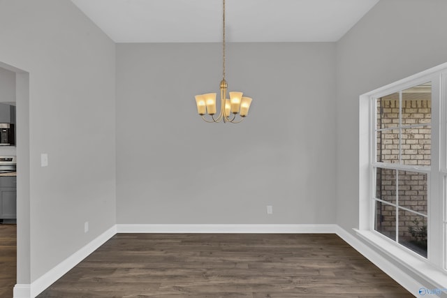 unfurnished dining area with a notable chandelier and dark hardwood / wood-style floors