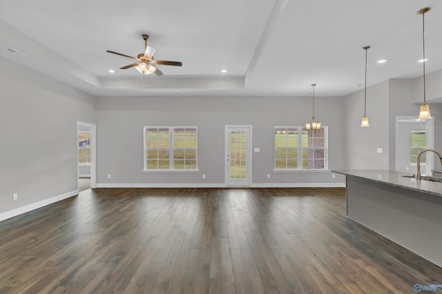 unfurnished living room with a wealth of natural light, sink, ceiling fan, and dark hardwood / wood-style flooring