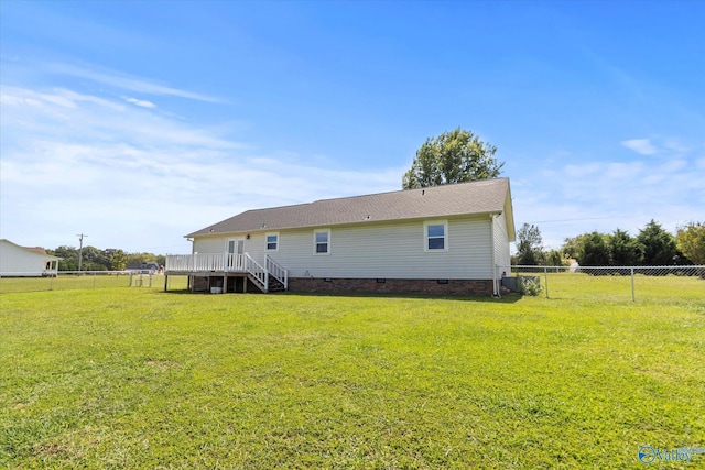 rear view of property with a wooden deck and a yard