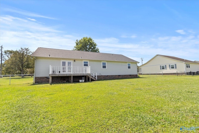 rear view of house with a lawn and a deck