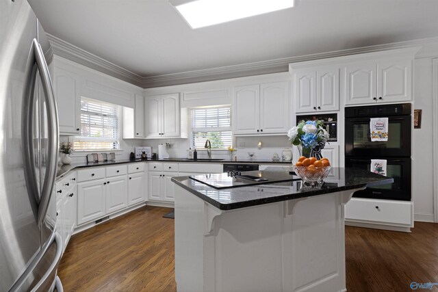 2907 Madrey Ln, Hampton Cove, AL 35763 - kitchen with dobule oven black, freestanding refrigerator, white cabinetry, and a breakfast bar