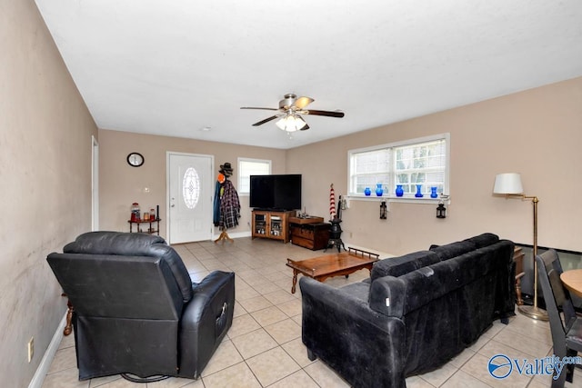 living room featuring baseboards, ceiling fan, and light tile patterned floors